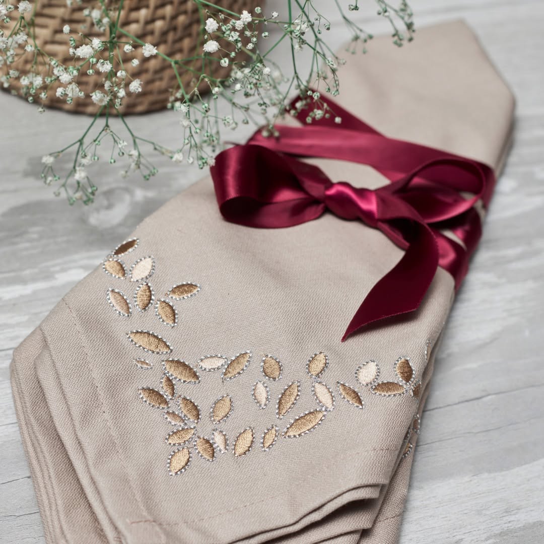Neutral Melchiah table linen embroidered with champagne leaves