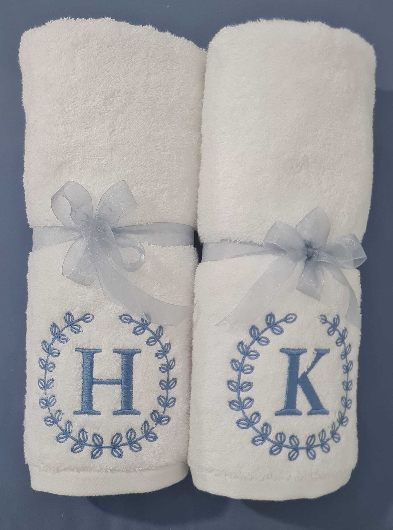 White Melchiah towels embroidered with blue wreath monograms