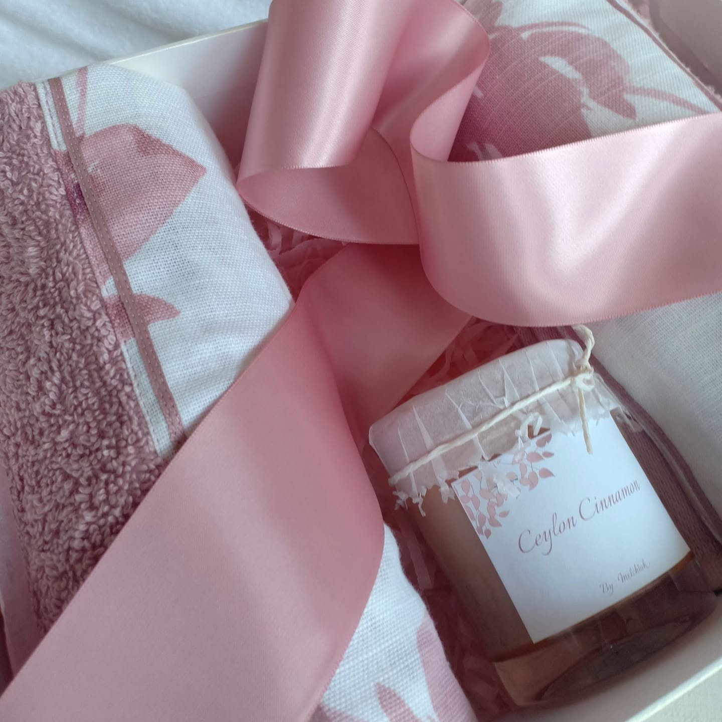 Pink Melchiah towel and scented candle gift box tied with satin ribbon