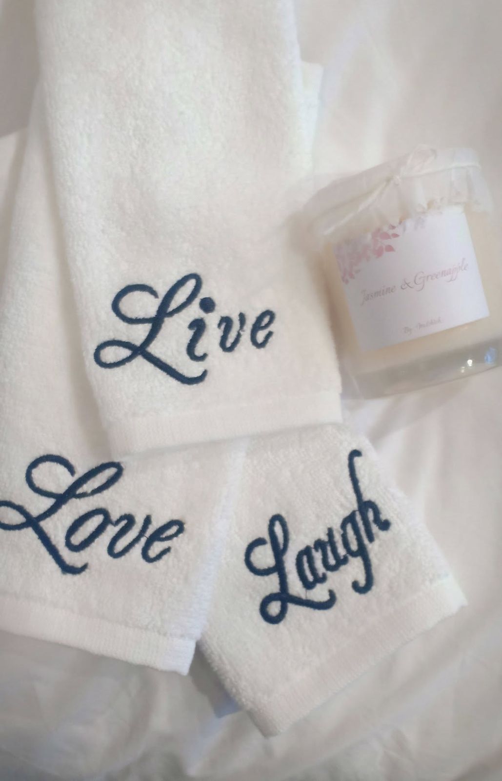 White Melchiah towels embroidered Live Love Laugh in a flowing script