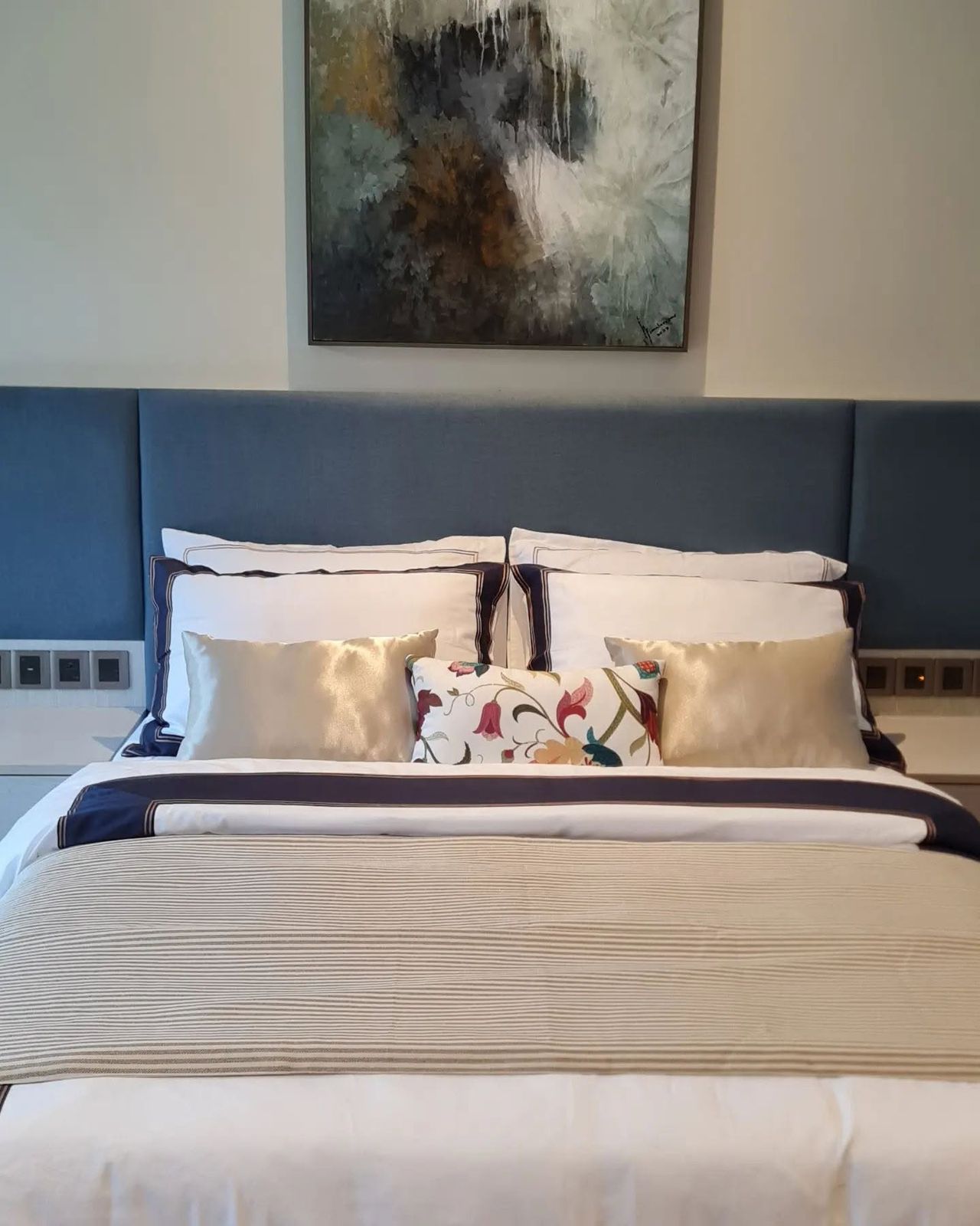 Neutral Melchiah bedding styled with a patterned accent pillow in a guest room