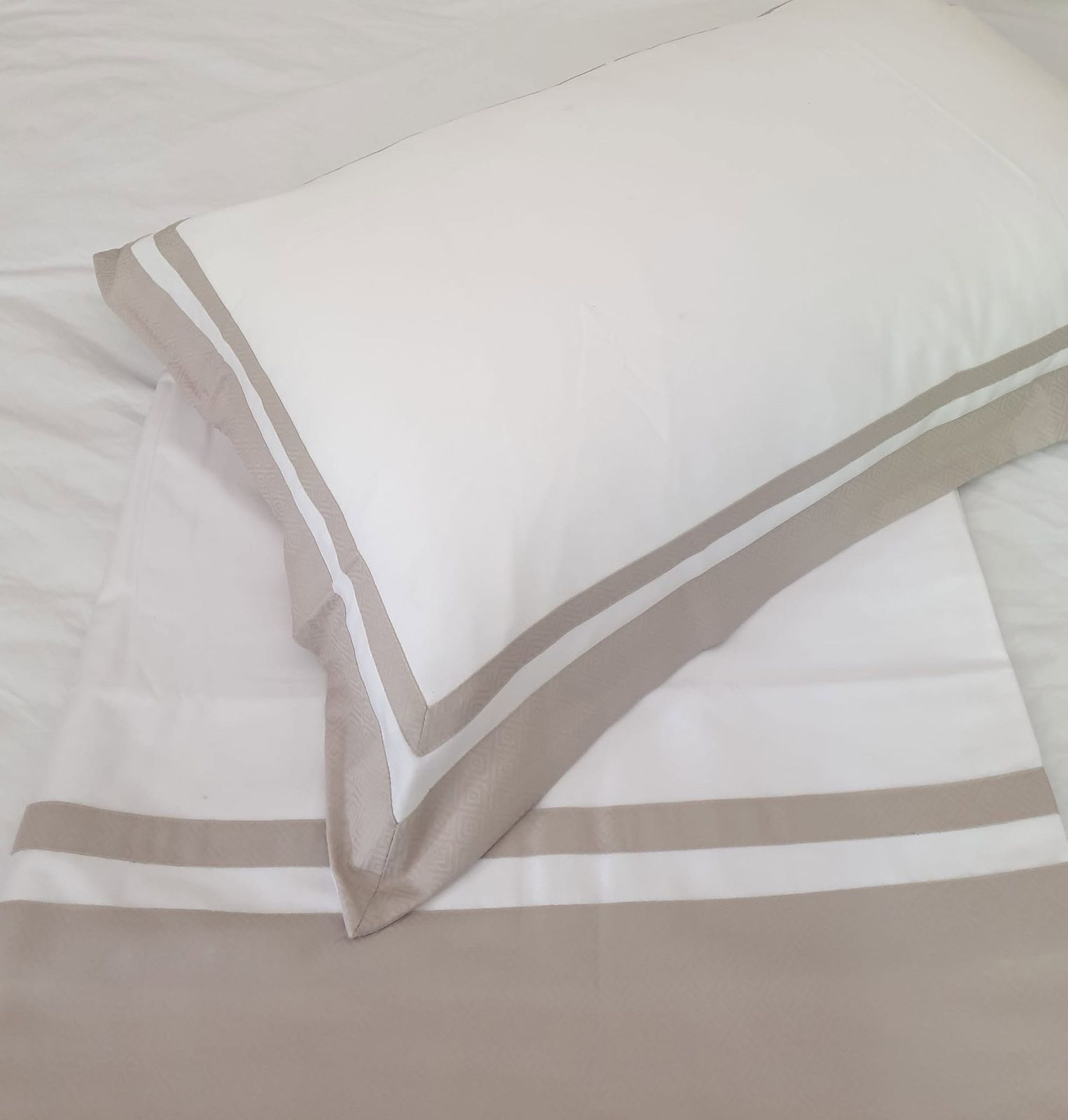 White Melchiah bedding finished with a tailored taupe border