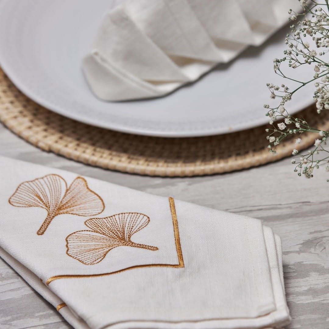 Powder-blue vine embroidered Melchiah napkins on crisp white linen