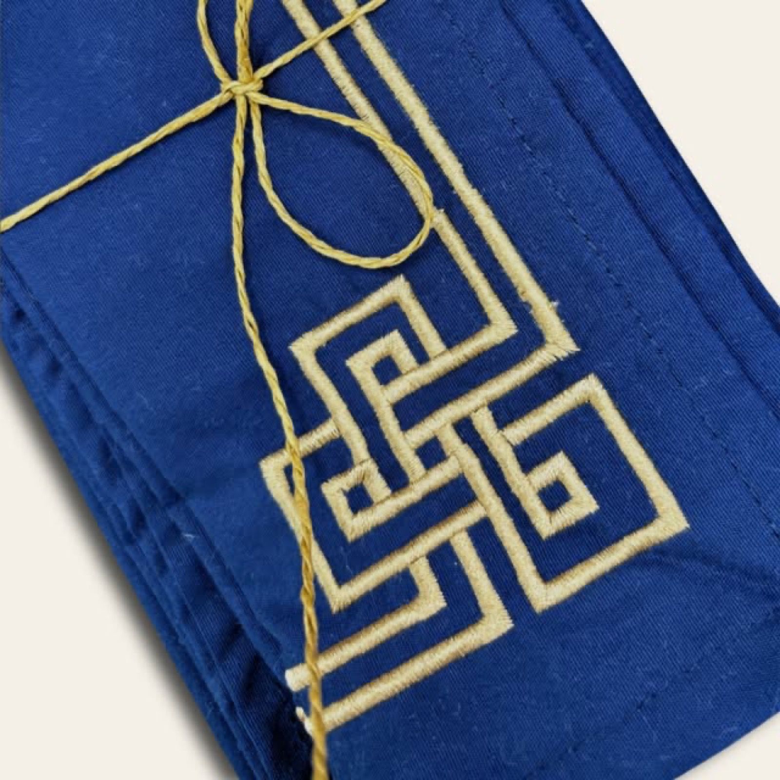 Navy Melchiah table linen finished with a fine gold embroidered key motif